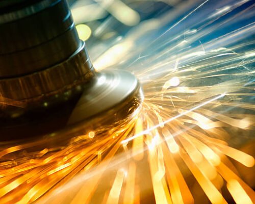 Electric wheel CNC grinding on steel structure produces colorful sparks