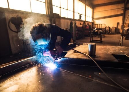 professional-welder-protective-uniform-helmet-welding-metal-part-workshop_342744-518